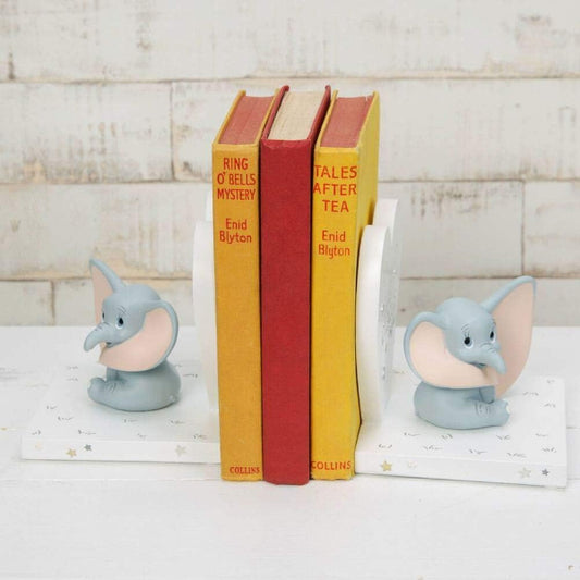 Bookends shaped like elephants holding books on a wooden surface
