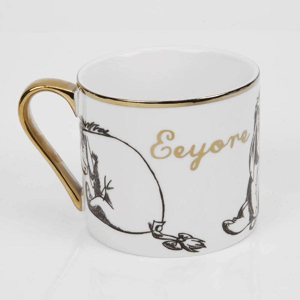 Mug with gold handle and decorative text on a white background.