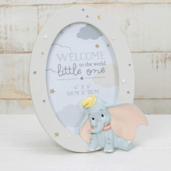 Oval photo frame with Dumbo the elephant design and text 'Welcome to the world little one' on a wooden background.