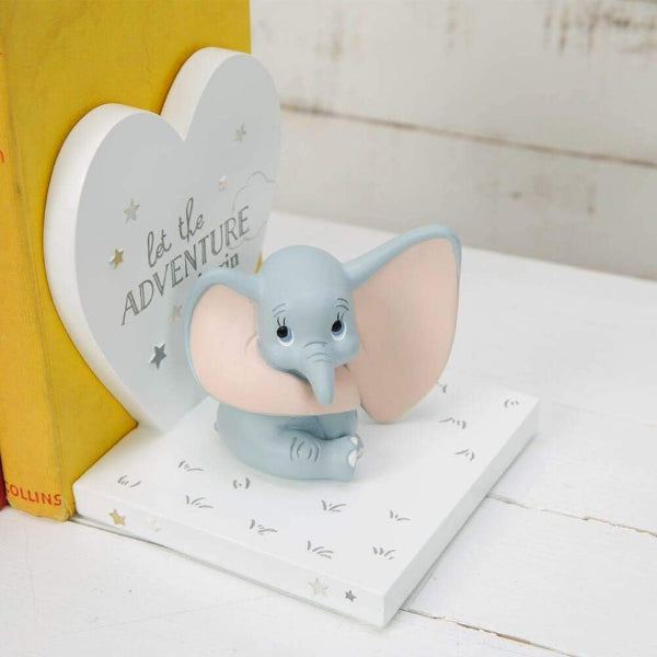Decorative elephant figurine with heart-shaped bookend on a white surface