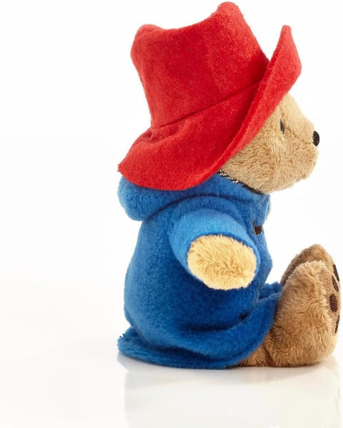 Plush toy bear wearing a red hat and blue coat on a white background