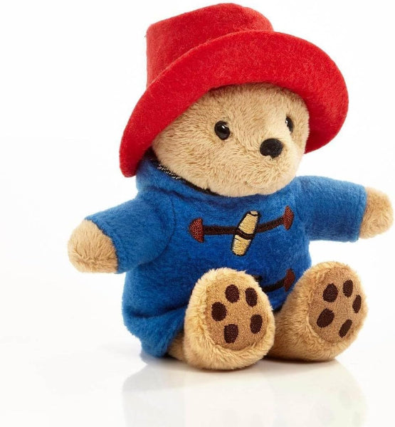 Plush toy bear wearing a red hat and blue outfit on a white background