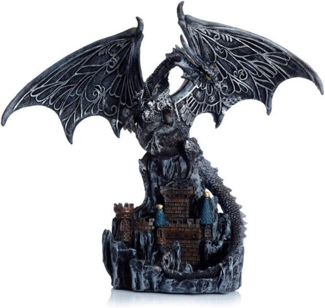 Dragon figurine with open wings over a castle on a white background