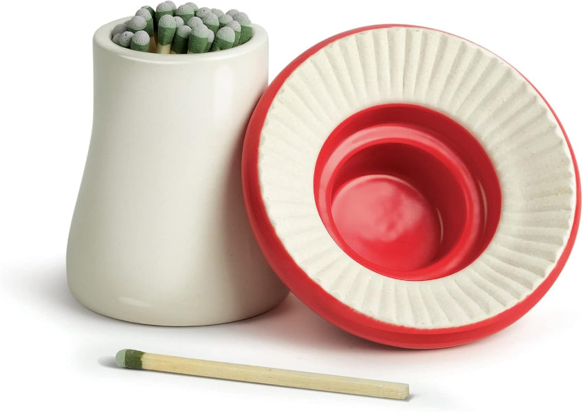 White ceramic match striker with red interior and matches on a white background