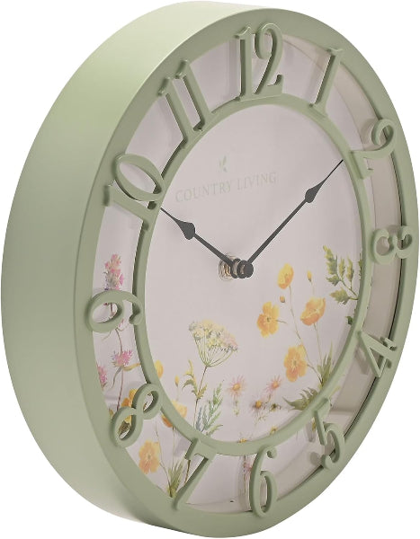 Decorative wall clock with floral design and green frame on a white background
