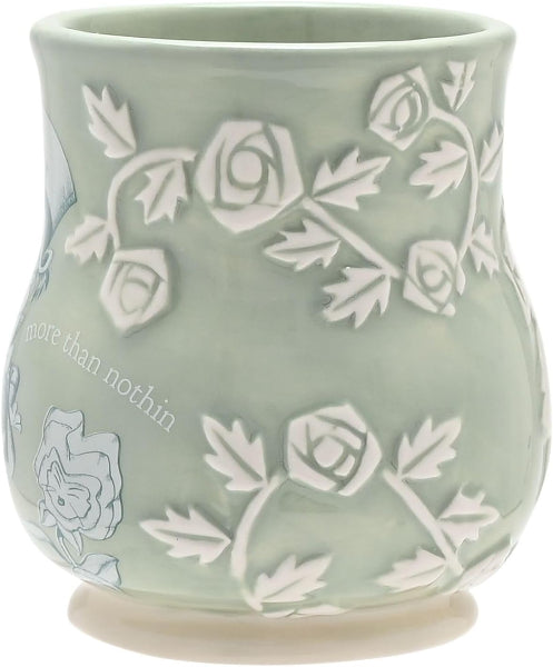 Green ceramic mug with white floral patterns and text on a white background