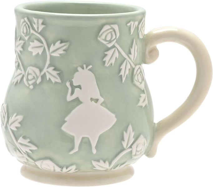 Green mug with white floral and silhouette design on a white background