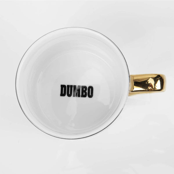 White mug with gold handle and 'DUMBO' text on a white background