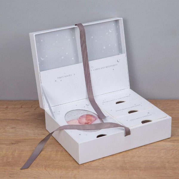 White jewelry box with a gray ribbon on a wooden surface
