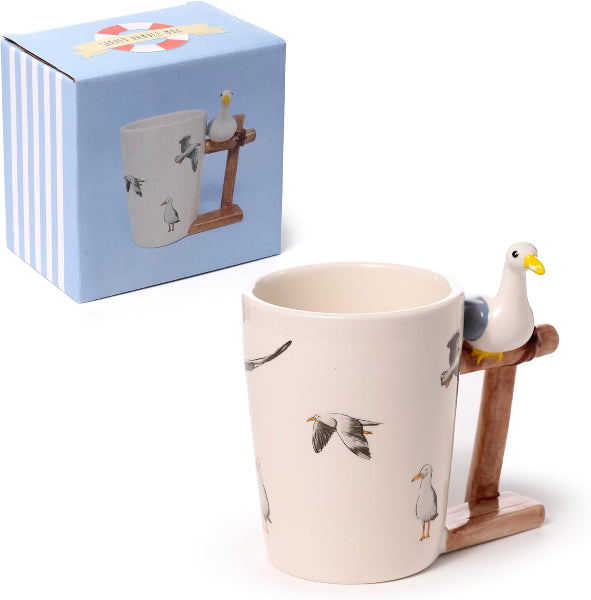 Mug with seagull design and stand, next to a matching box