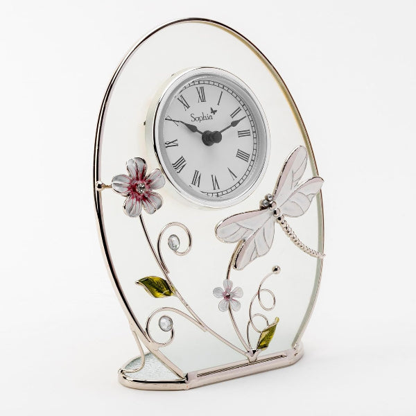 Decorative clock with floral and dragonfly designs on a white background