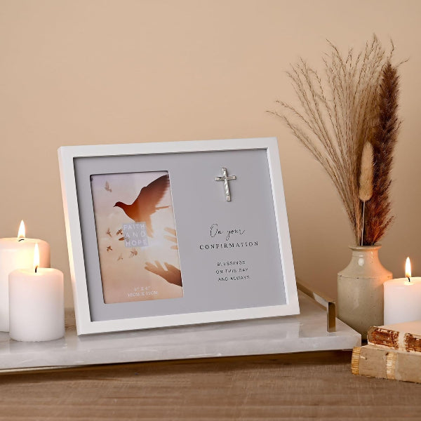 Framed card with religious design on a table with candles and decor