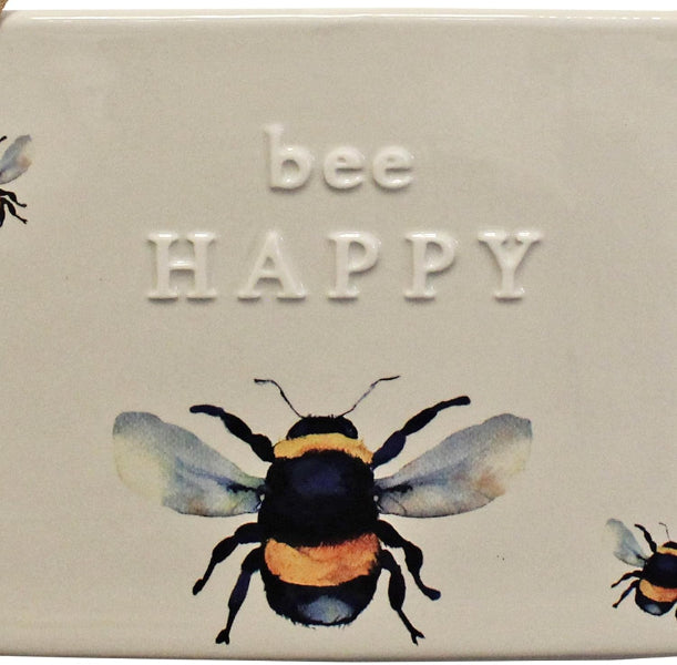 Decorative tile with a bee illustration and 'bee HAPPY' text on a beige background