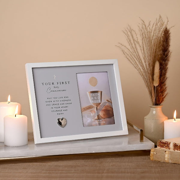 Framed photo with text and a cup on a table with candles and decor
