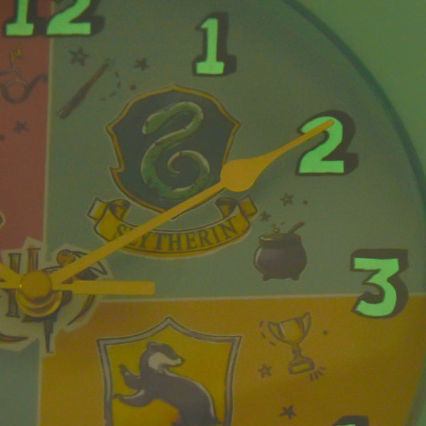 Clock with Slytherin emblem and other symbols on a green background