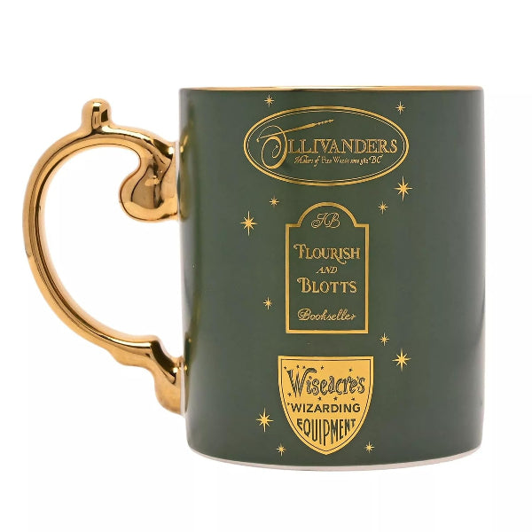 A dark green ceramic mug with a gold handle and gold printed designs featuring the words 'Ollivanders', 'Flourish and Blotts', and 'Wizcrag's Wizarding Equipment'.