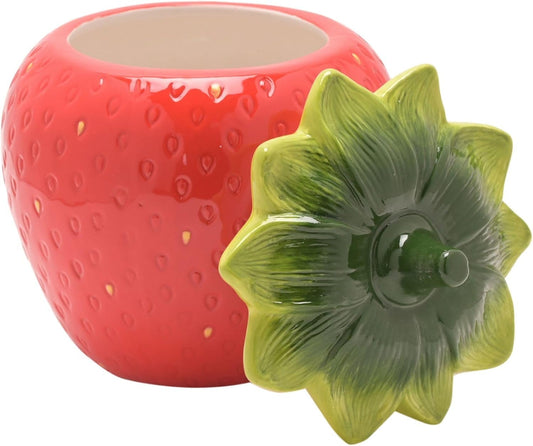 Red ceramic strawberry-shaped container with a green lid on a white background