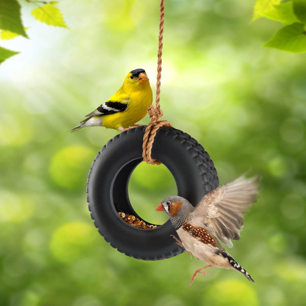 Two birds on a tire swing with a green blurred background