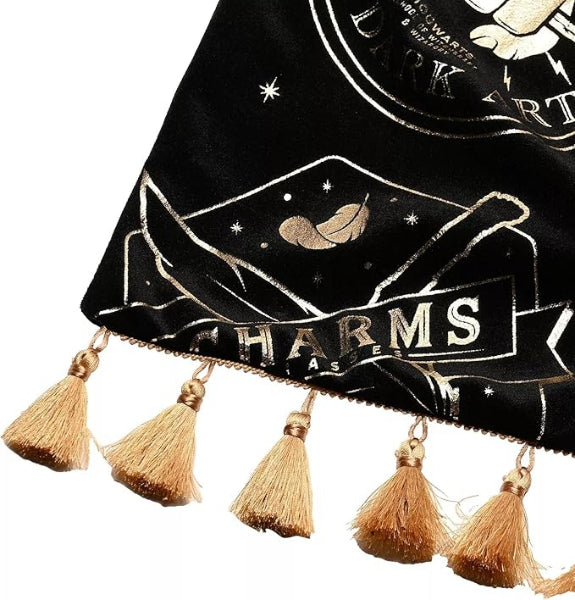 Black bag with gold tassels and 'Dark Arts Charms' text on a white background