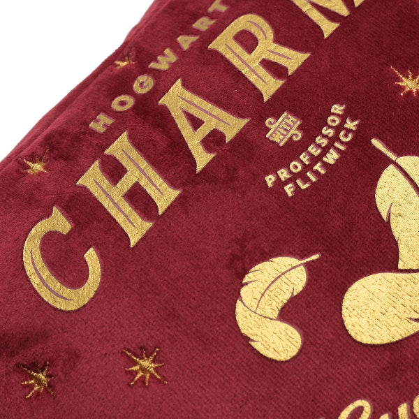 Red fabric with gold text and leaf designs, resembling a book cover.