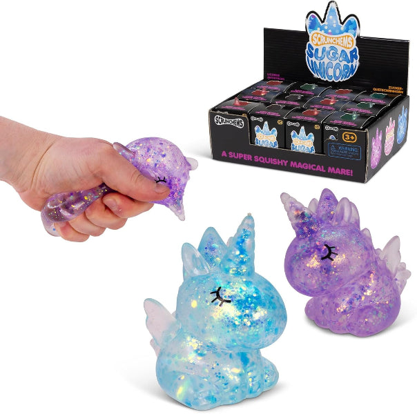 Squishy toy unicorn with glittery texture, held by a hand, with packaging in the background.