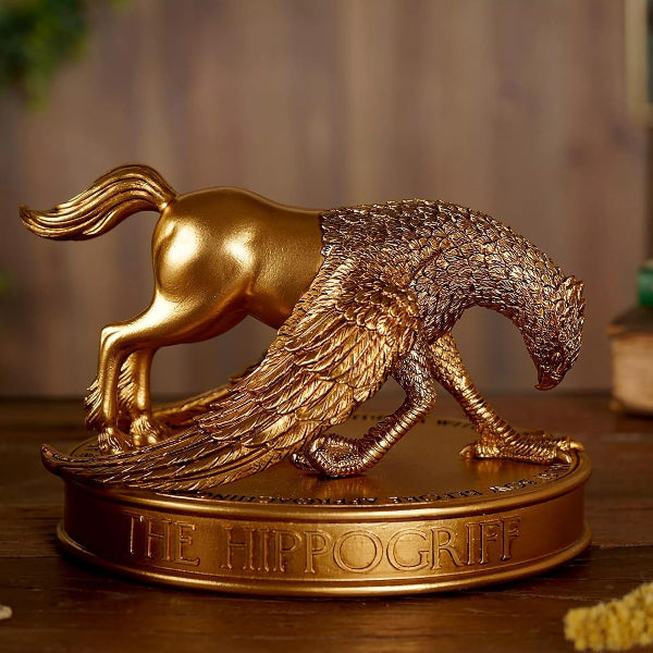 Gold statue of a hippogriff on a wooden surface with a blurred background