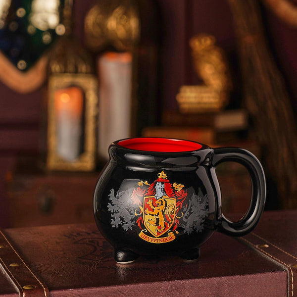 Black mug with red interior featuring a crest on a wooden surface with decorative background