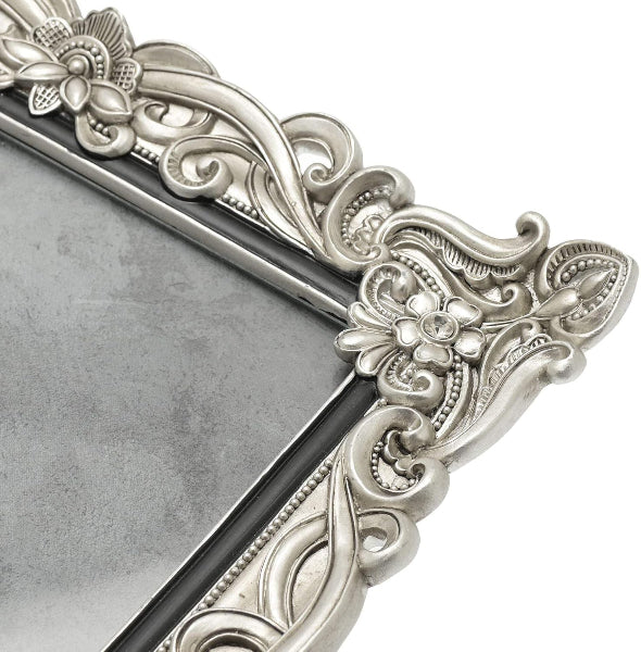 Decorative silver frame with intricate designs on a white background
