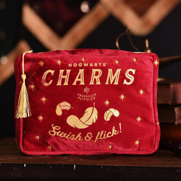 Red pouch with 'Hogwarts Charms' text and tassel on a dark background