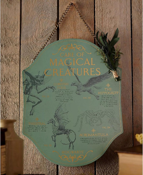 Decorative sign with illustrations of magical creatures on a wooden background