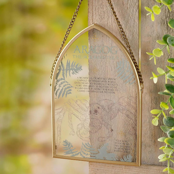 Decorative metal sign with engraved text and illustrations, hanging outdoors.
