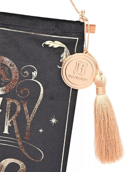 Decorative book with a tassel and circular emblem on a black background