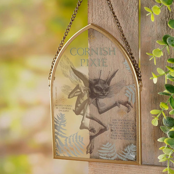 Decorative sign with a fairy design and 'Cornish Pixie' text, hanging outdoors.
