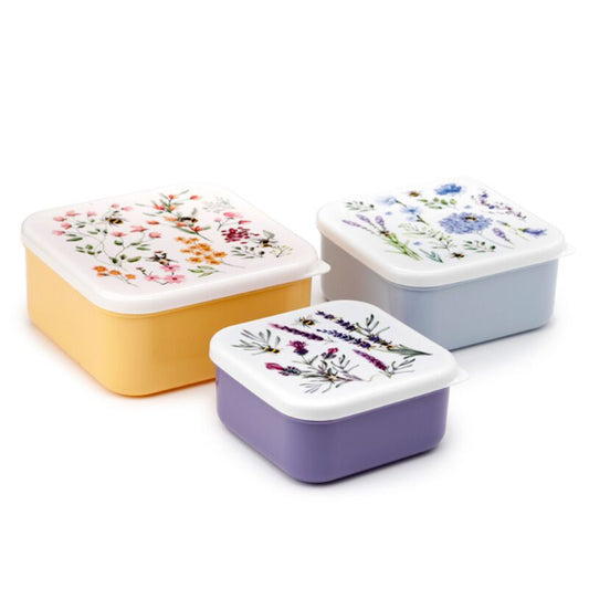 Three rectangular food containers with floral designs on lids against a white background