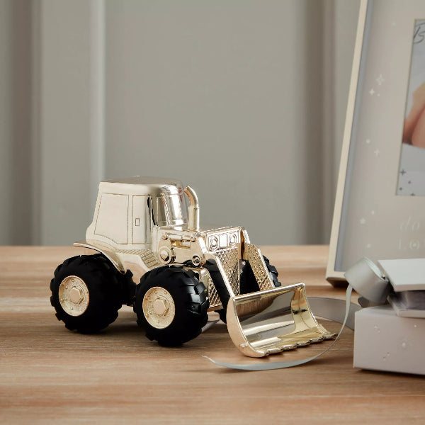 Gold toy bulldozer on a wooden surface with a neutral background