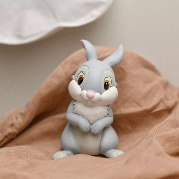 Cartoon rabbit figurine holding a heart on a brown surface