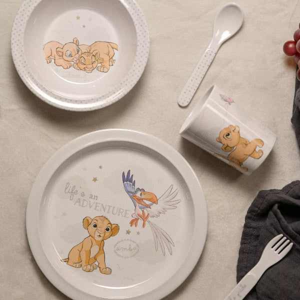 Children's tableware set with character illustrations on plates, mug, and cutlery.