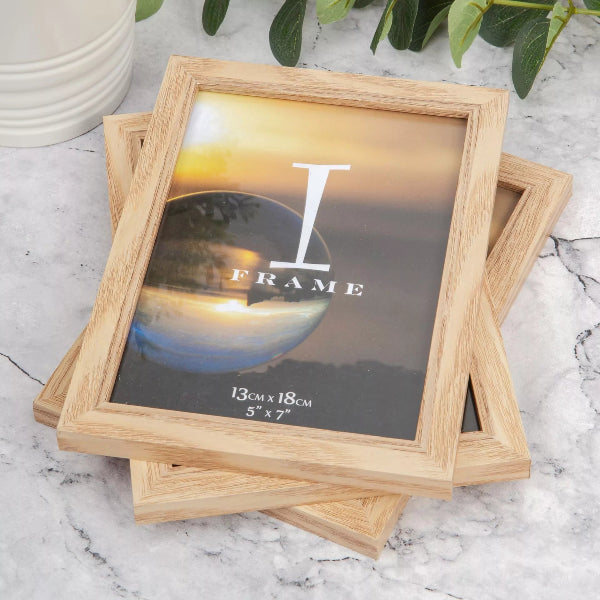Wooden picture frame with 'I Frame' branding on a marble surface