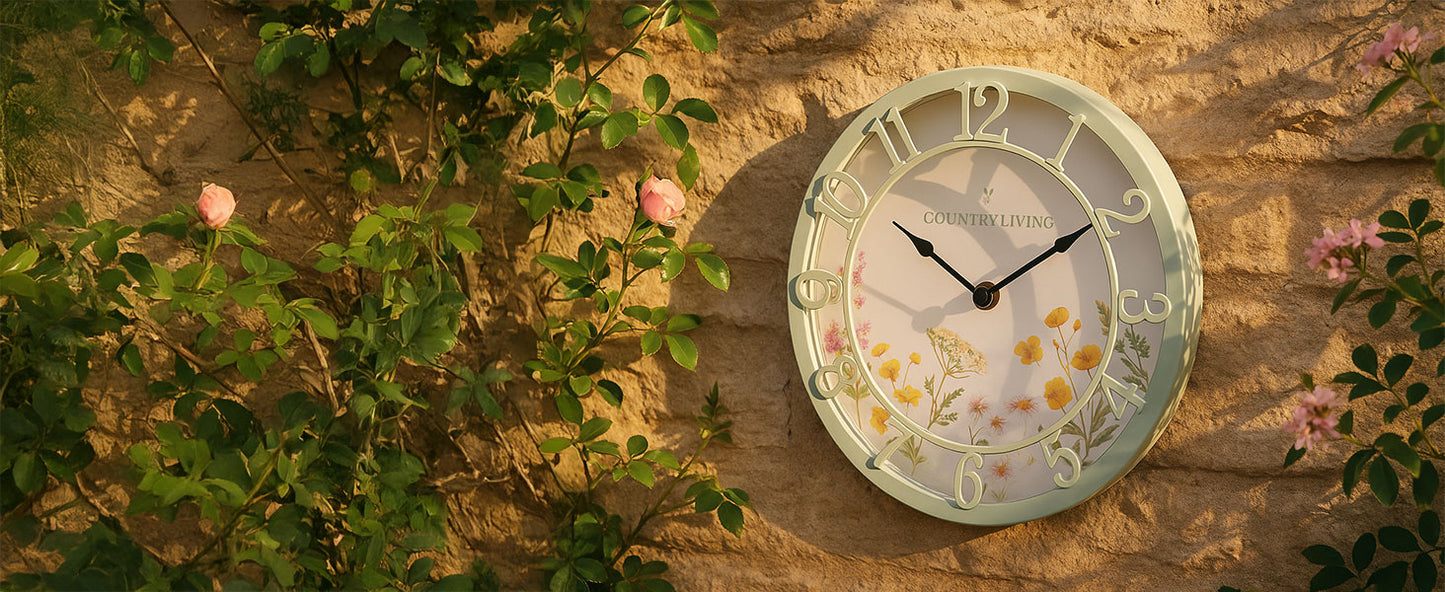 Decorative clock with floral design on a stone wall with greenery