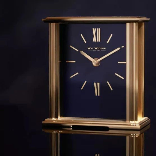 Gold-framed clock with navy face on a dark background