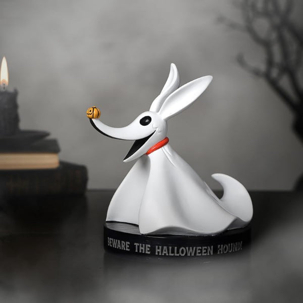 White dog figurine with a black base labeled 'Beware the Halloween Hound' on a dark surface.