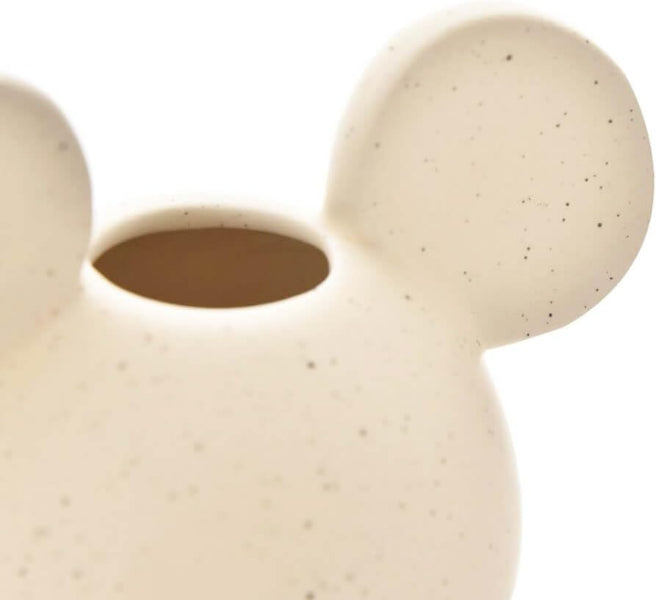Close-up of a beige ceramic vase with a textured surface on a white background