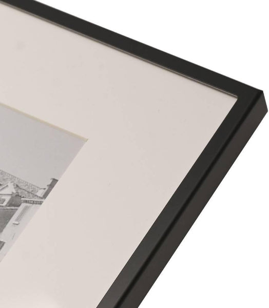 Close-up of a black picture frame corner with a white mat and photo inside.