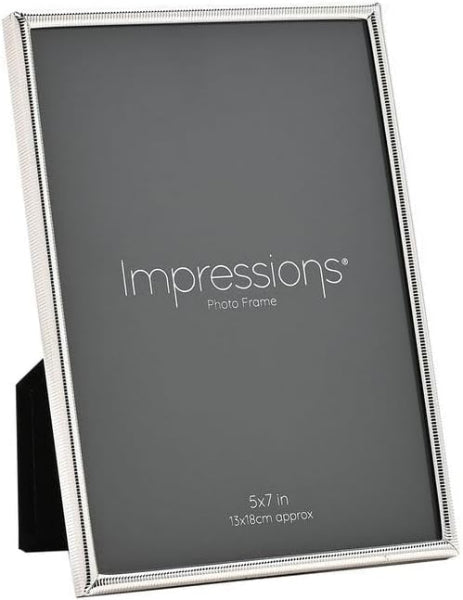A silver-toned picture frame with a textured beaded border, shown standing upright on a black display stand against a white background. The frame is shown empty with the brand name 'Impressions' printed on the insert.