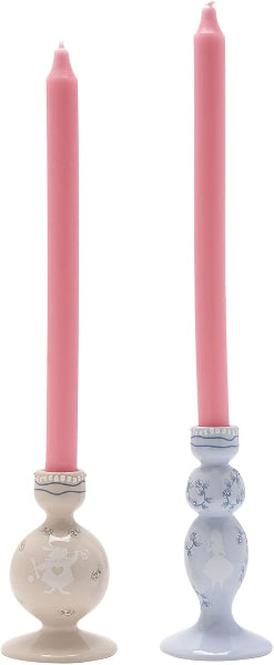 Two candlesticks with pink candles on a white background