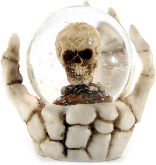 Skeleton hand holding a transparent sphere with a skull inside on a white background
