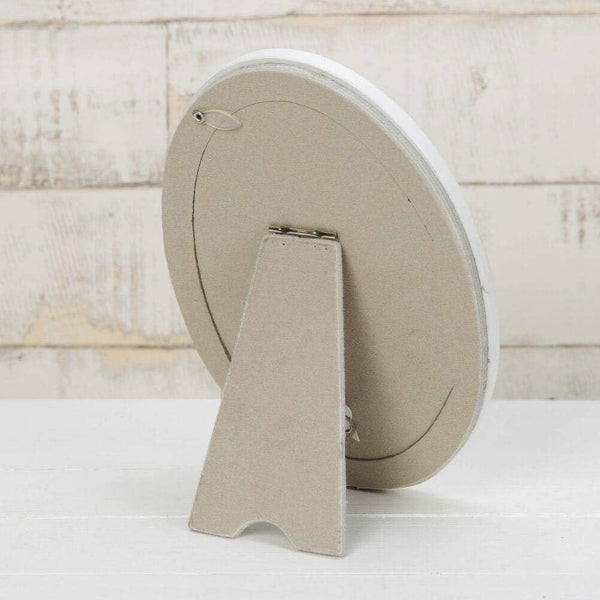 Round beige object with a stand on a light wooden background
