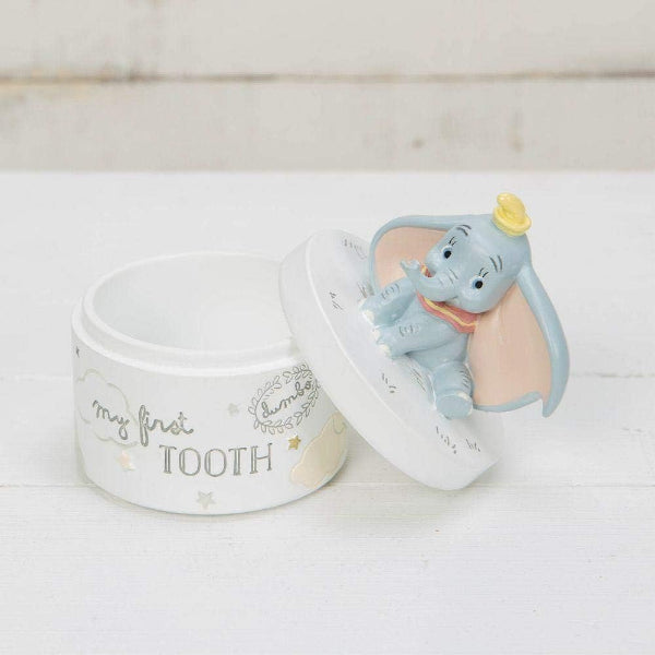 Decorative container with Dumbo figurine and 'my first tooth' text on a white background