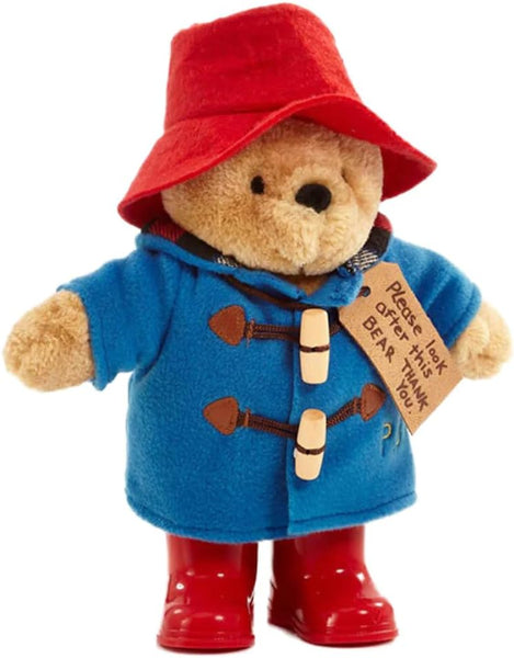 Plush toy bear wearing a red hat, blue coat, and red boots on a white background