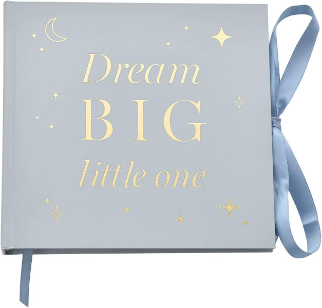A square keepsake album or photo book with a light blue-gray cover, gold foil stars and moon, and the words 'Dream BIG little one' in gold lettering, tied with a matching ribbon on a white background.